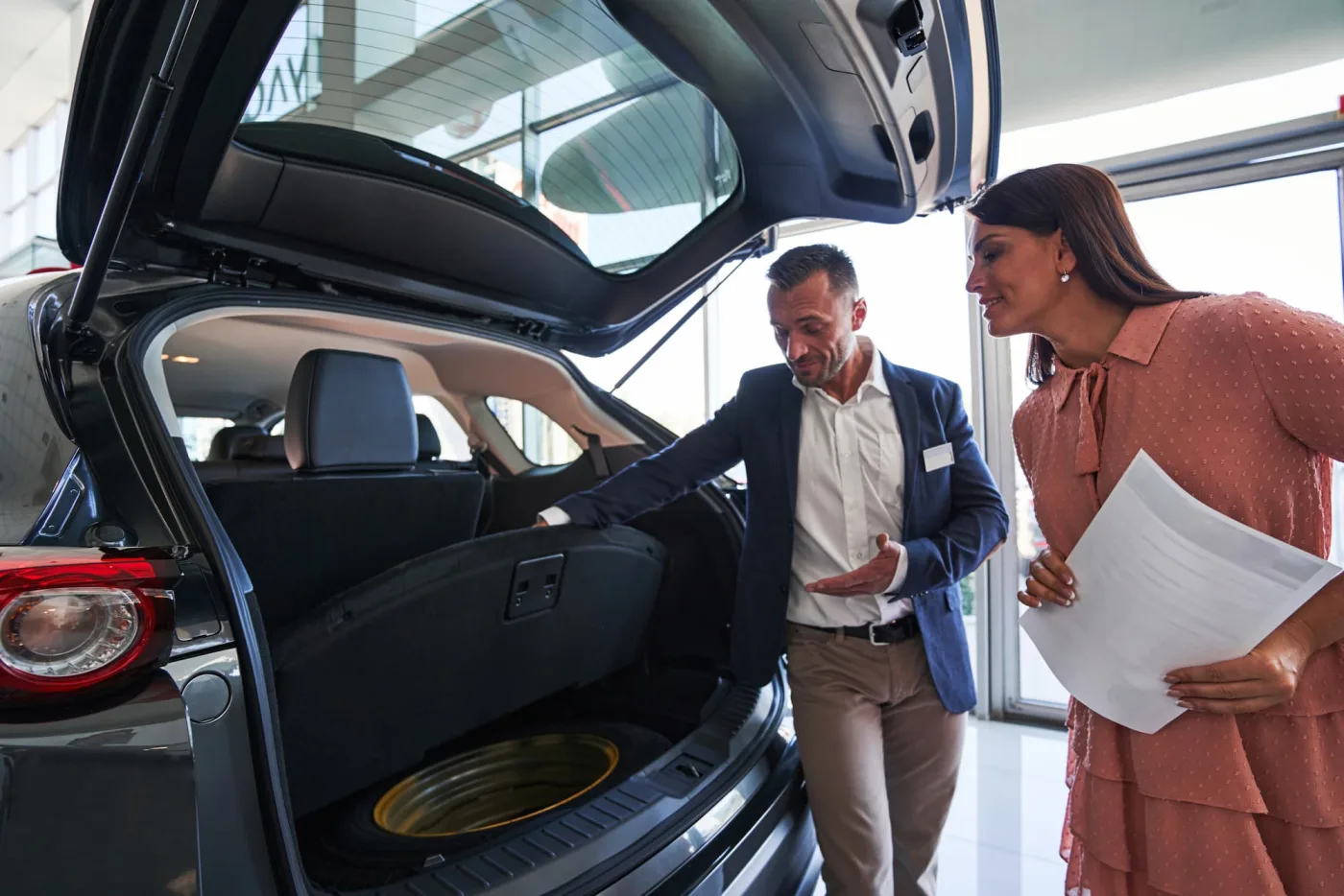 Buyer looking over a new car with a dealer