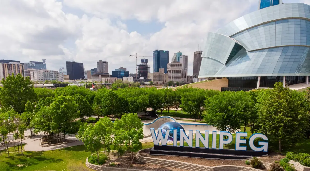 Winnipeg sign at The Forks with the downtown skyline